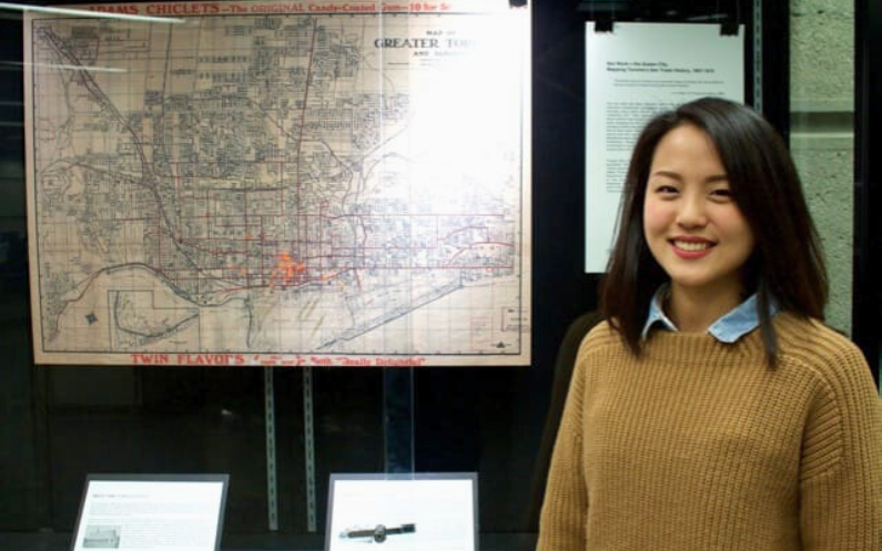 Picture of a woman standing in front of a map.