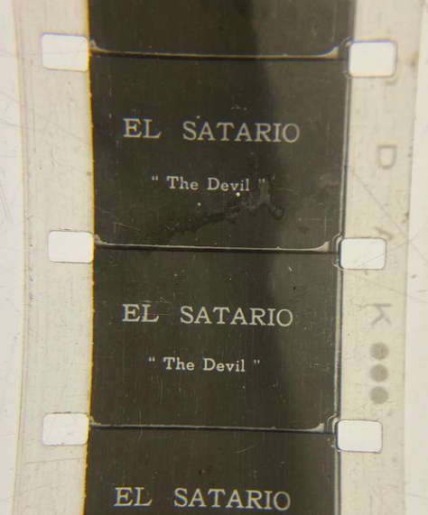 White film tape with the text EL SATARIO written on it and the words "The Devil" underneath in quotation