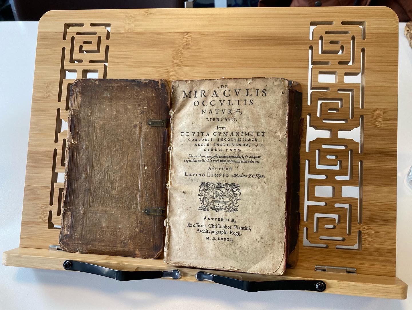 open book displayed on a wood stand